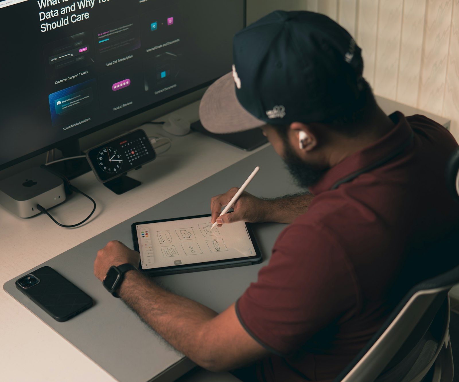 Pessoa desenhando um layout em tablet ao lado do computador